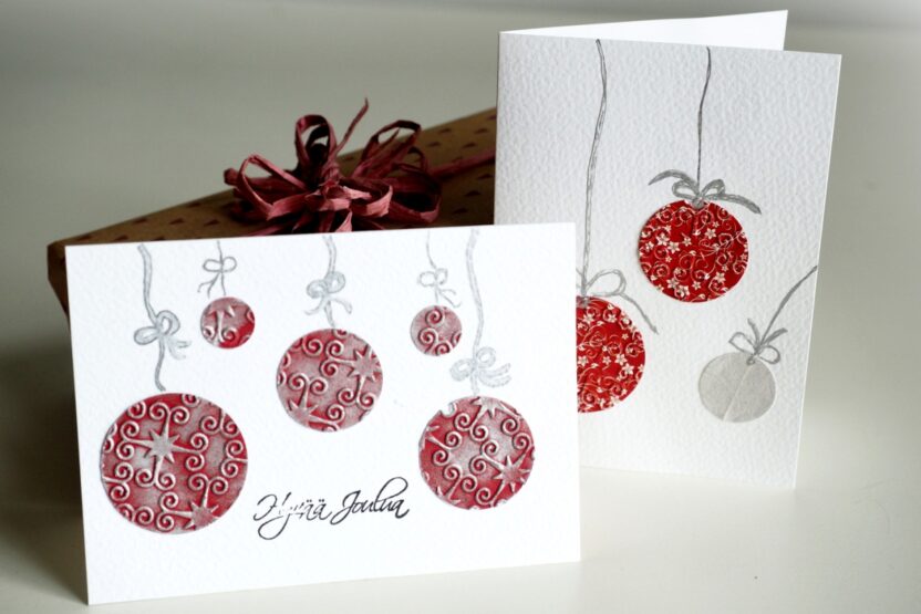 kaksi punavalkoista joulukorttia, joissa kuusenpalloja